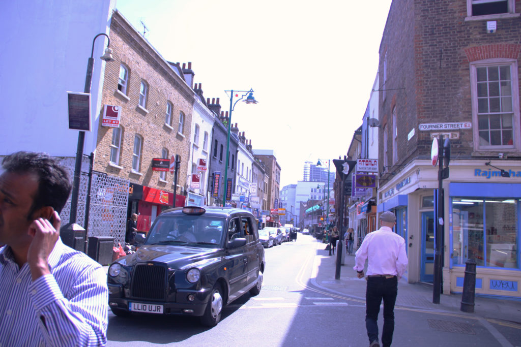 London taxi passes Brick Lane. 